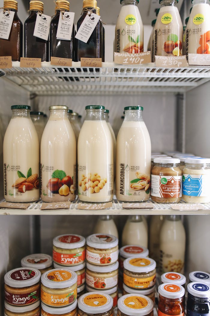 A variety of plant-based milk bottles on display in a refrigerator, showcasing vegan and dairy-free options.